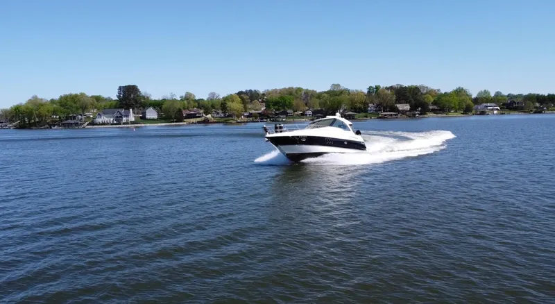 Slide: The Image of 2009 Cruisers Yachts 420 Sports Coupe cruising on a serene lake under clear skies. - 3