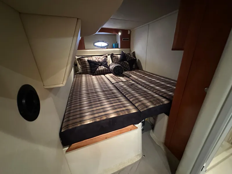 Slide: The Image of 2009 Cruisers Yachts 420 Sports Coupe cabin with striped bedding and cozy interior. - 33