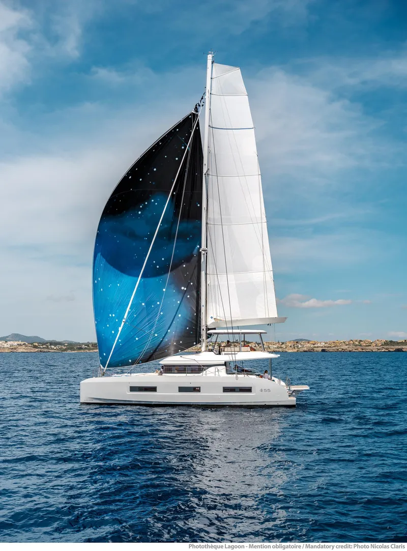 Slide: The Image of 2025 Lagoon 55 catamaran sailing on open sea under clear blue sky. - 2