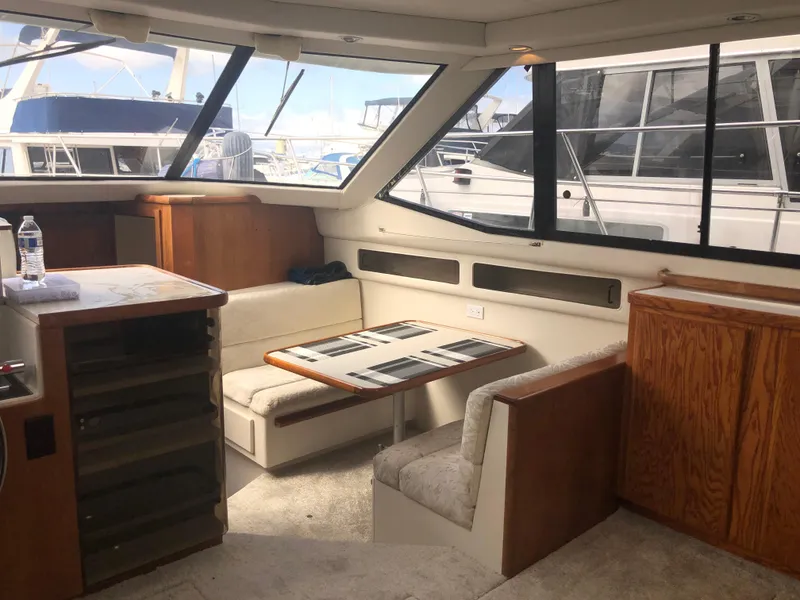 Slide: The Image of Interior of 1993 Carver 350 Aft Cabin yacht with dining area and large windows. - 12
