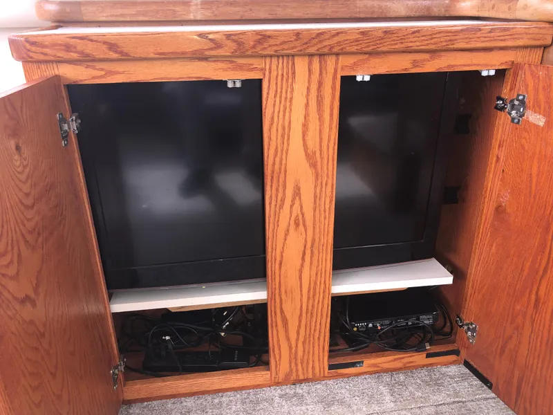Slide: The Image of Open wooden cabinet with electronics inside on a 1993 Carver 350 Aft Cabin yacht. - 13