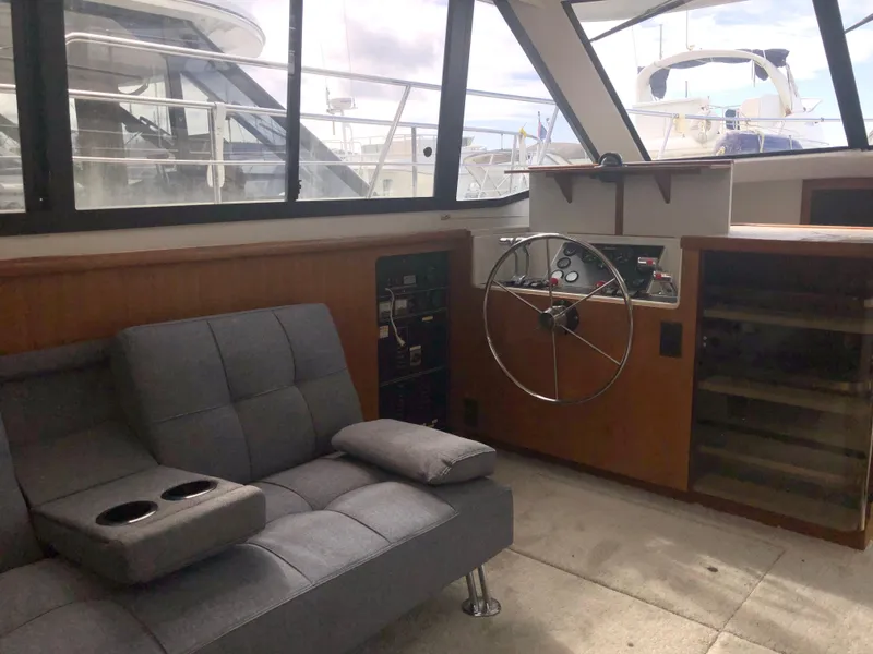 Slide: The Image of 1993 Carver 350 Aft Cabin interior with helm, gray seating, and large windows. - 15