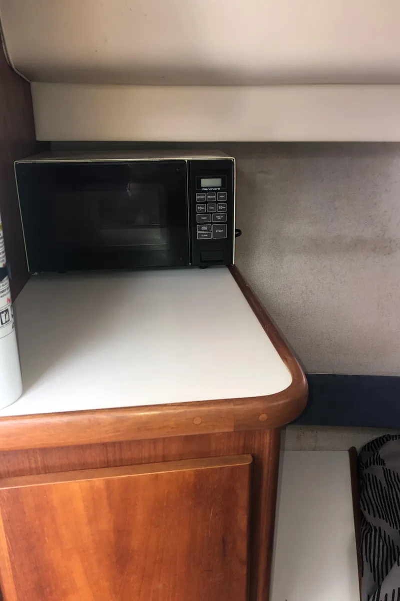 Slide: The Image of 1993 Carver 350 Aft Cabin interior with microwave on wooden counter. - 22
