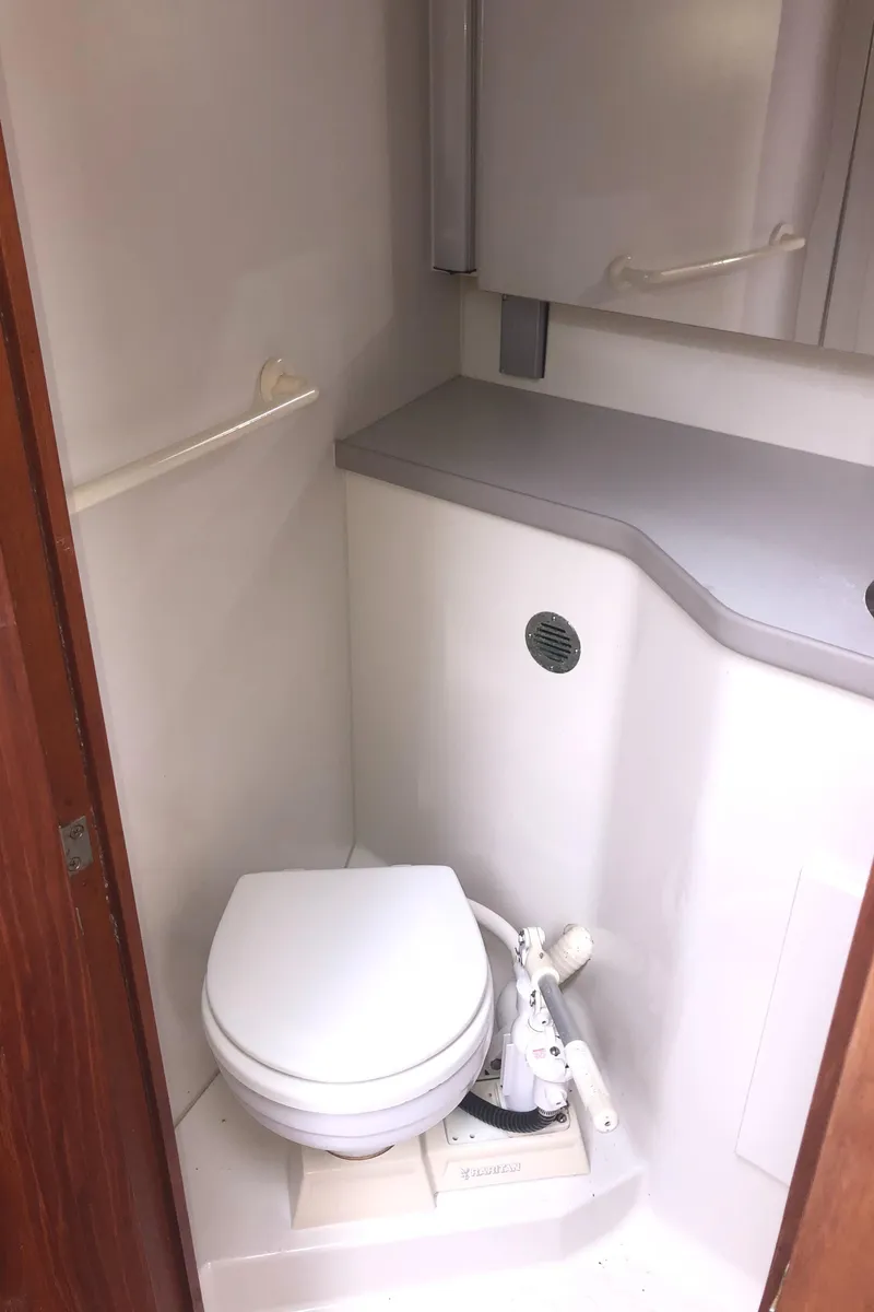 Slide: The Image of 1993 Carver 350 Aft Cabin bathroom with toilet and storage cabinets. - 23