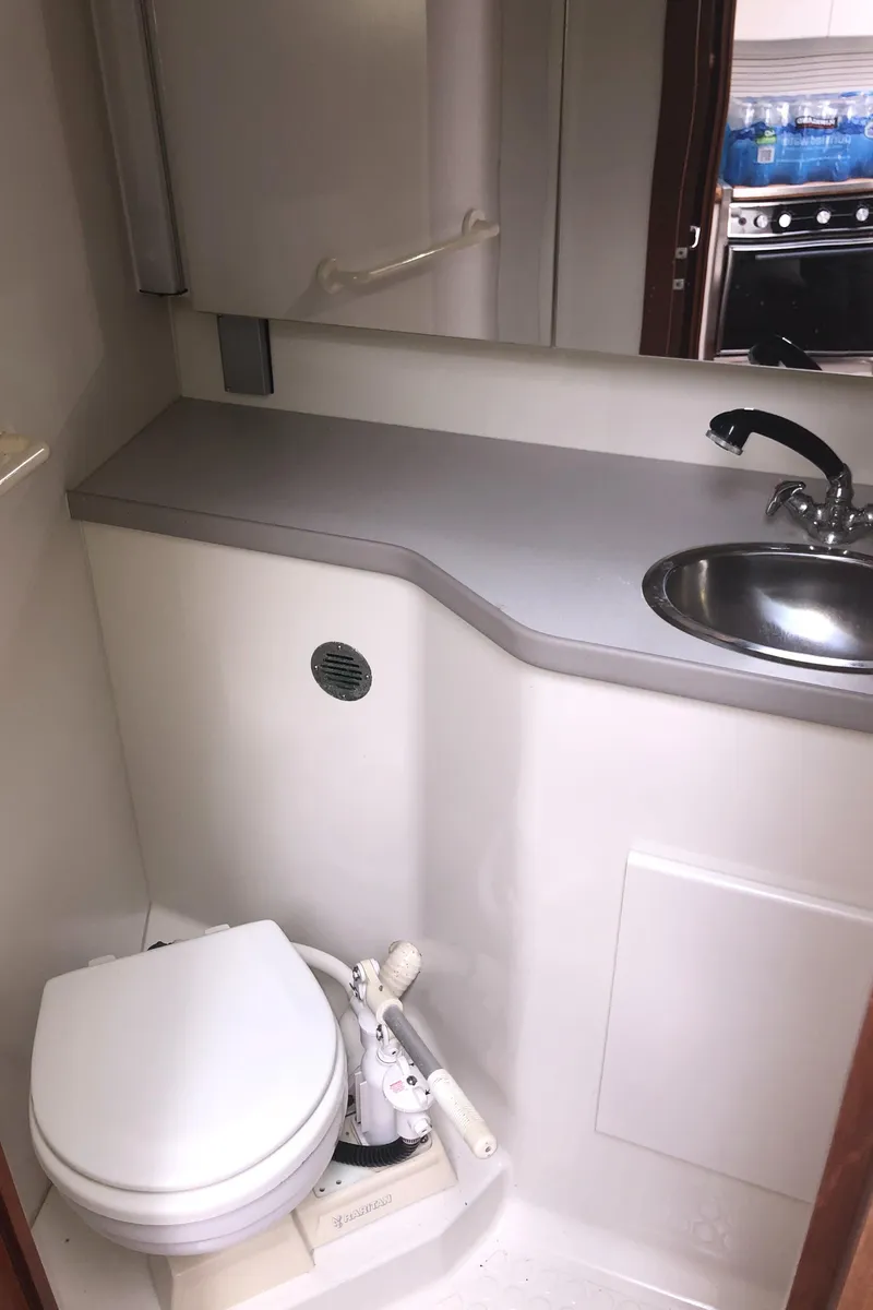 Slide: The Image of 1993 Carver 350 Aft Cabin bathroom with sink, toilet, and mirror. - 24