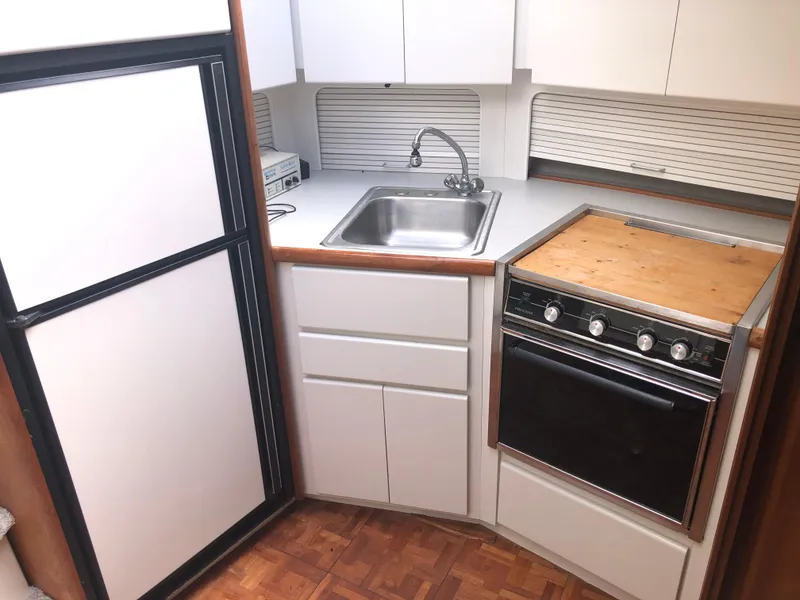 Slide: The Image of 1993 Carver 350 Aft Cabin kitchen with sink, stove, and refrigerator. - 26