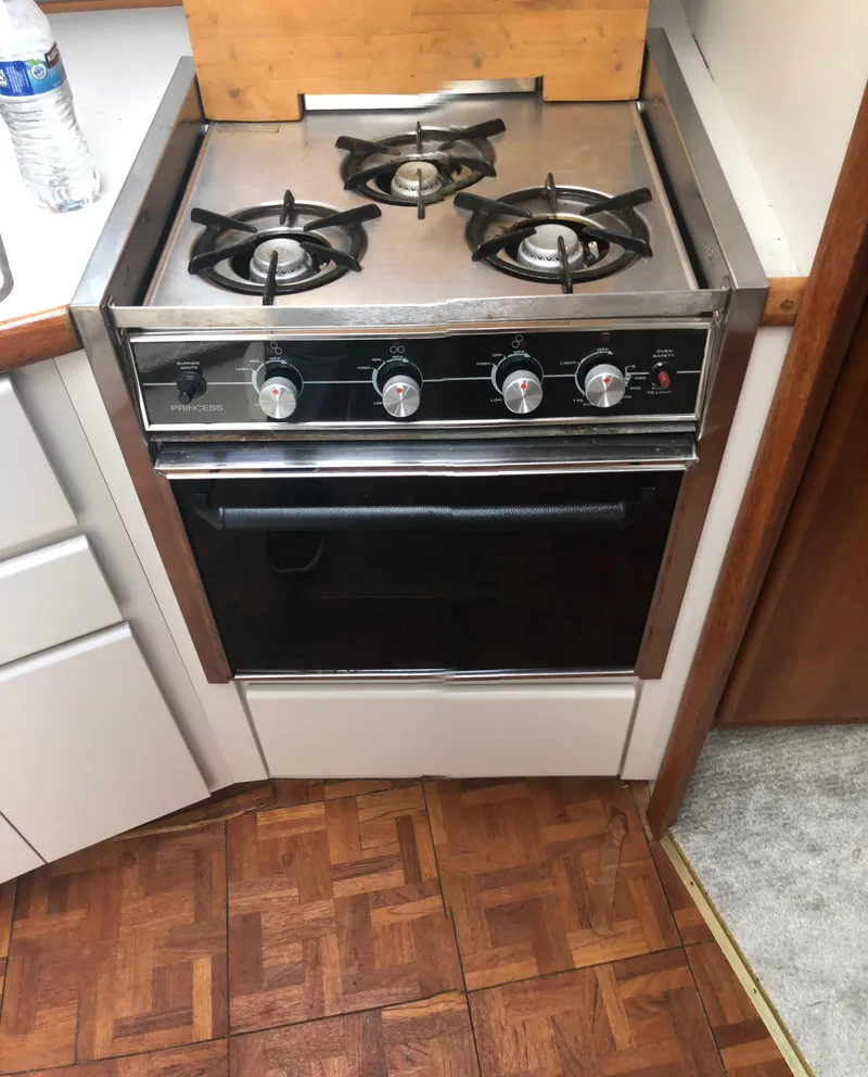 Slide: The Image of 1993 Carver 350 Aft Cabin kitchen stove with three burners and oven. - 27