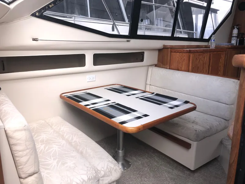 Slide: The Image of 1993 Carver 350 Aft Cabin interior with dining area, featuring cushioned seating and a table. - 30