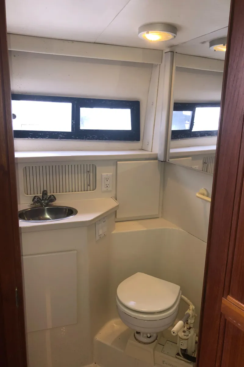 Slide: The Image of 1993 Carver 350 Aft Cabin bathroom with sink, toilet, and window. - 34