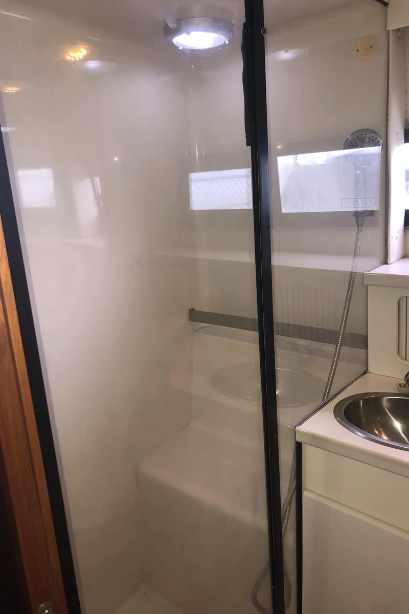 Slide: The Image of 1993 Carver 350 Aft Cabin bathroom with shower, sink, and natural light. - 35