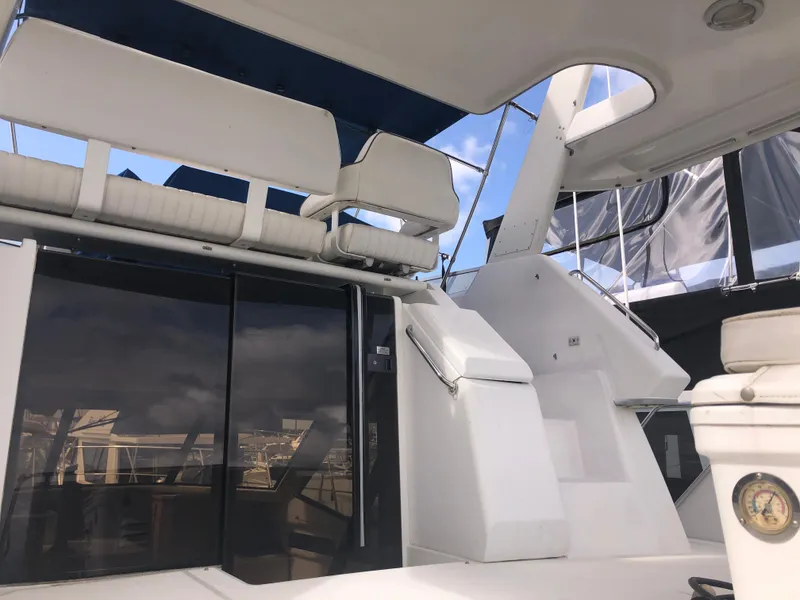 Slide: The Image of 1993 Carver 350 Aft Cabin yacht with white seating and stairs under a blue canopy. - 4