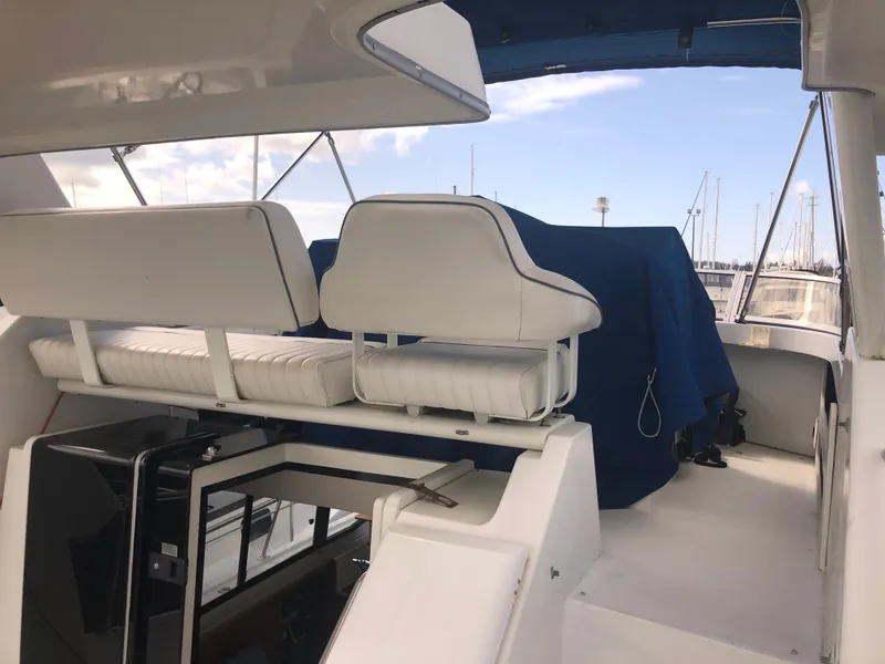 Slide: The Image of 1993 Carver 350 Aft Cabin yacht interior with white seating and marina view. - 8