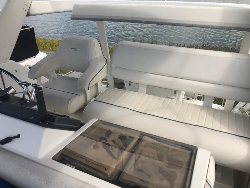 Slide: The Image of 1993 Carver 350 Aft Cabin boat interior with white seating, near water. - 9