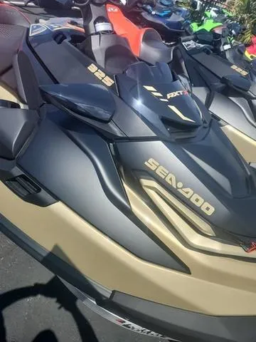 Slide: The Image of 2025 Sea-Doo Waverunner RXT-X in black and gold, parked outdoors. - 3