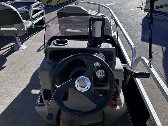 Slide: The Image of 2021 Sun Tracker BASS BUGGY® 18 DLX boat console with steering wheel and navigation system. - 18