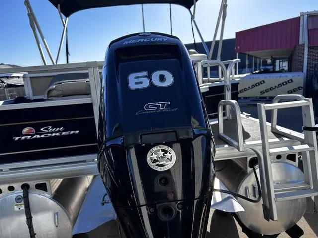 Slide: The Image of 2021 Sun Tracker BASS BUGGY® 18 DLX pontoon boat on trailer, under clear blue sky. - 6