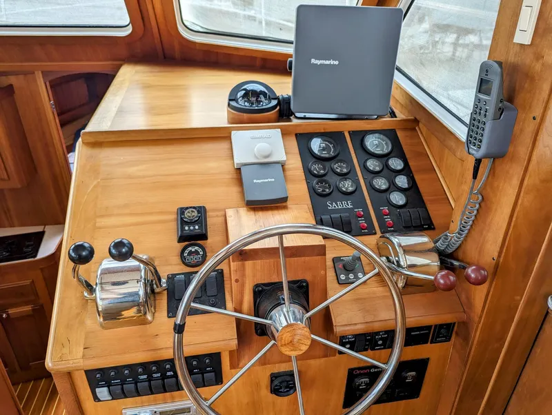 Slide: The Image of 2003 Sabre 36 Flybridge helm with steering wheel, controls, and navigation equipment. - 12