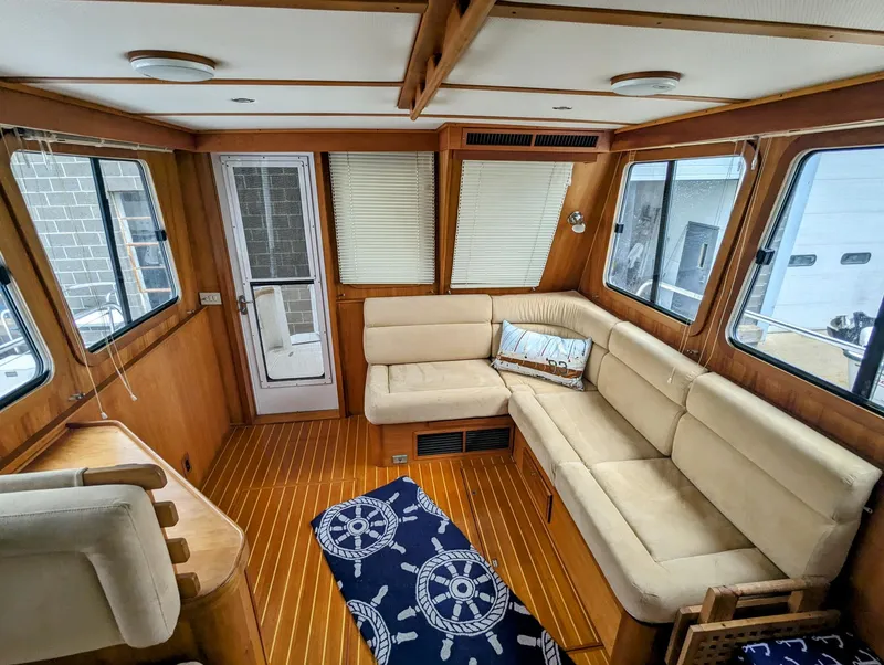 Slide: The Image of Interior of 2003 Sabre 36 Flybridge with beige seating and nautical-themed decor. - 14