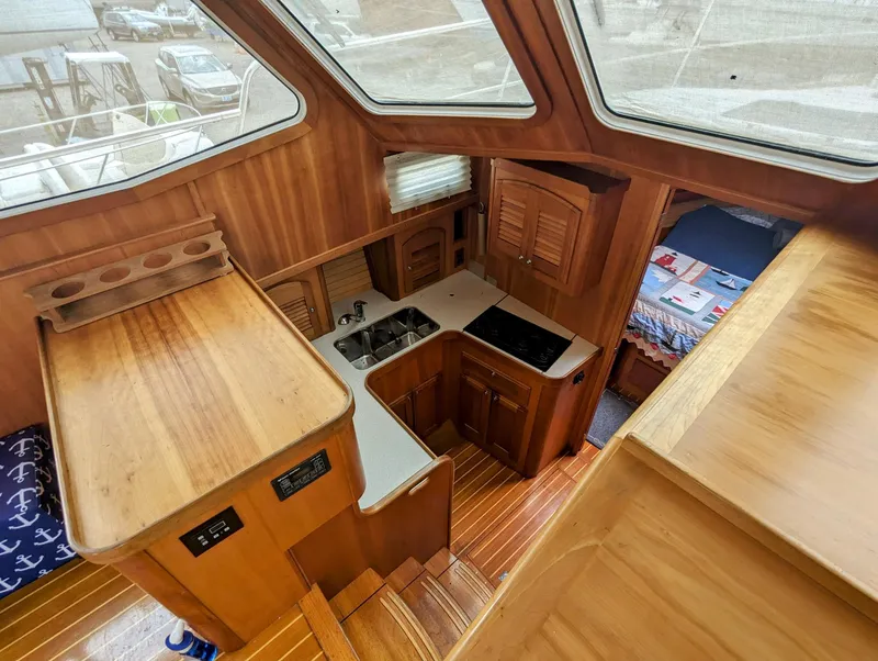 Slide: The Image of Interior of 2003 Sabre 36 Flybridge yacht, featuring wood cabinetry and compact kitchen area. - 19