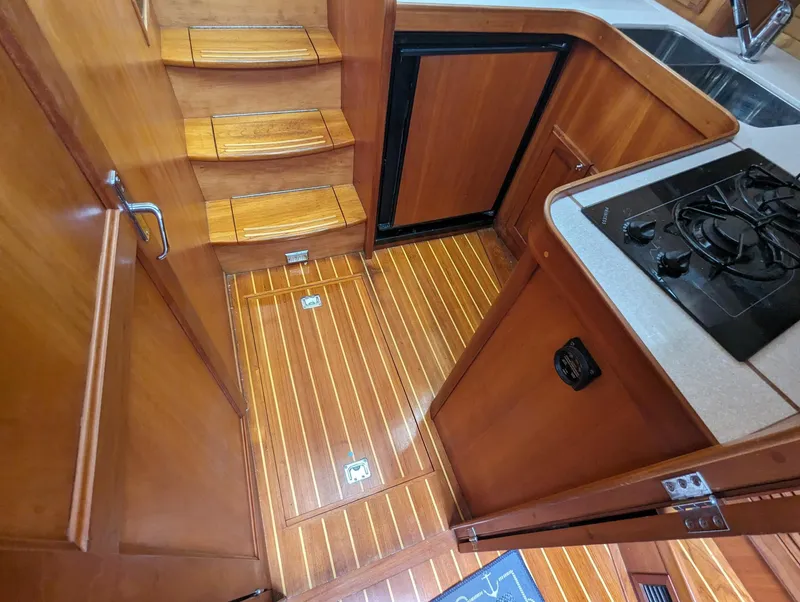 Slide: The Image of Interior of 2003 Sabre 36 Flybridge yacht with wooden flooring and compact kitchen area. - 25