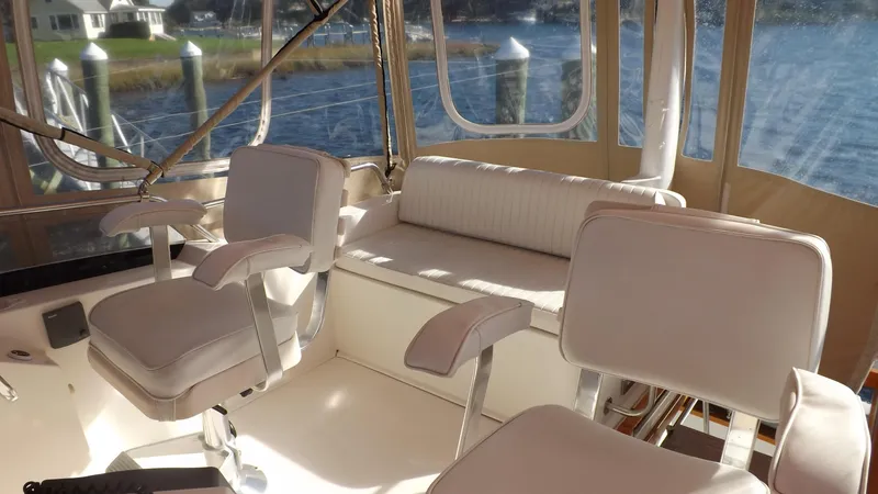 Slide: The Image of 2003 Sabre 36 Flybridge interior with white seating and scenic water view. - 34