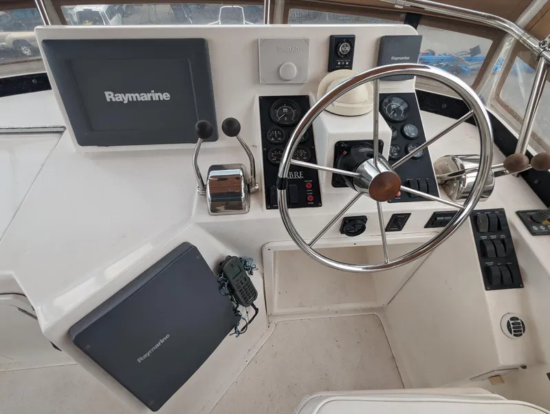 Slide: The Image of 2003 Sabre 36 Flybridge helm with Raymarine navigation equipment and steering wheel. - 37