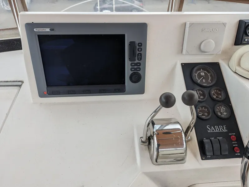 Slide: The Image of Control panel of a 2003 Sabre 36 Flybridge with navigation screen and throttle levers. - 38