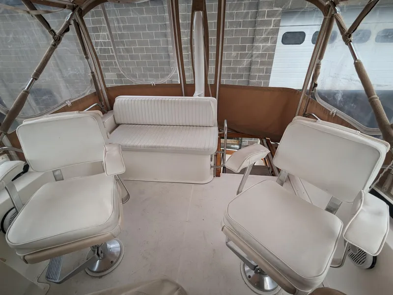 Slide: The Image of 2003 Sabre 36 Flybridge interior with white seating and clear enclosure. - 41