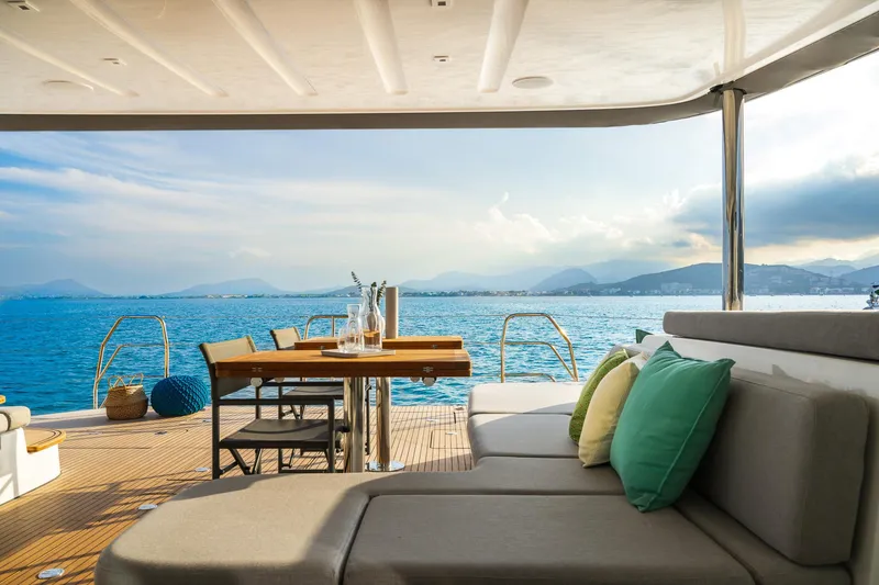Slide: The Image of Luxurious Lagoon 60 yacht deck with seating, table, and ocean view, 2025 model. - 13