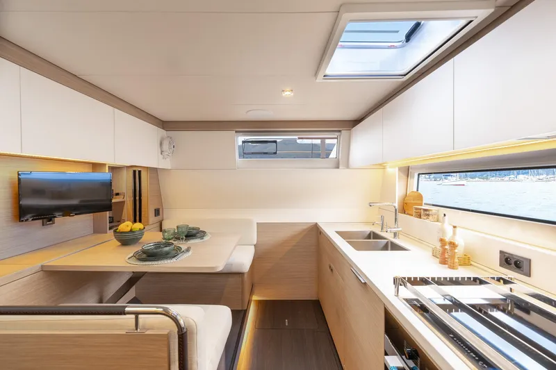 Slide: The Image of Modern interior of 2025 Lagoon 60 yacht with kitchen and dining area. - 29