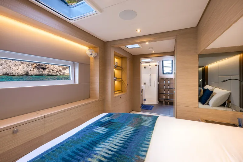 Slide: The Image of Luxurious interior of 2025 Lagoon 60 yacht cabin with modern design and scenic window view. - 34
