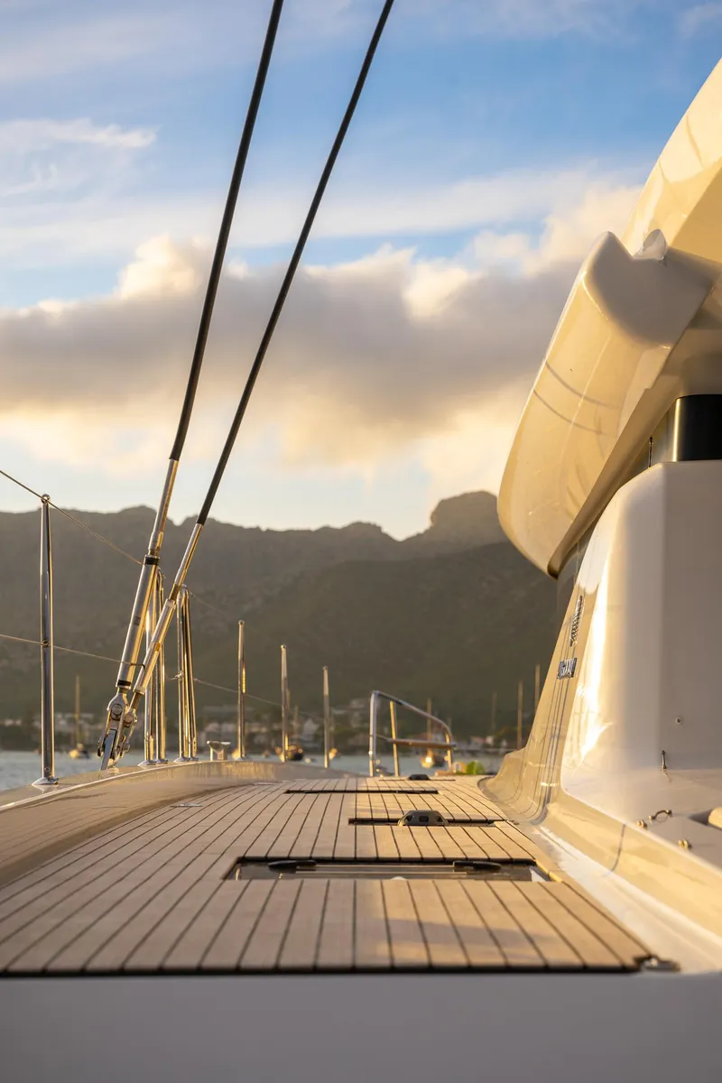 Slide: The Image of 2025 Lagoon 60 yacht deck with scenic mountain backdrop at sunset. - 9