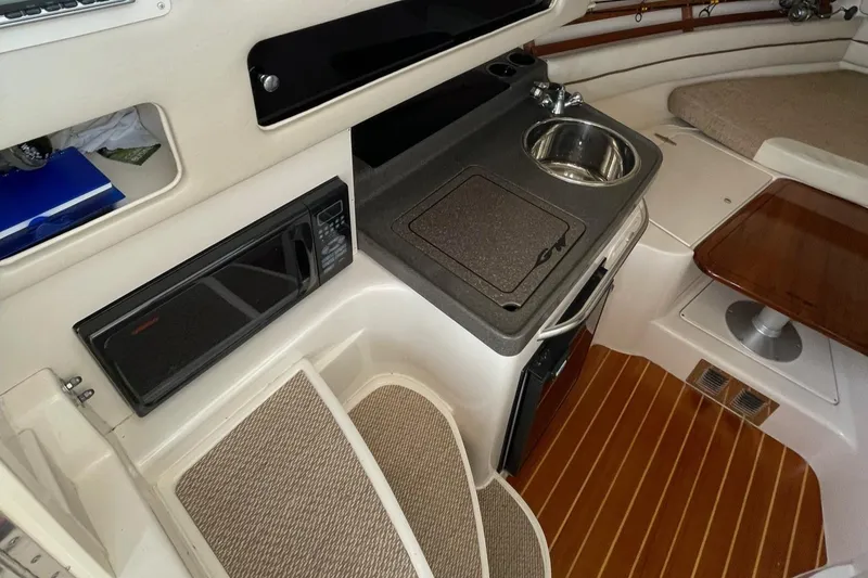Slide: The Image of 2005 Grady-White Marlin 300 cabin interior with kitchenette and seating area. - 12