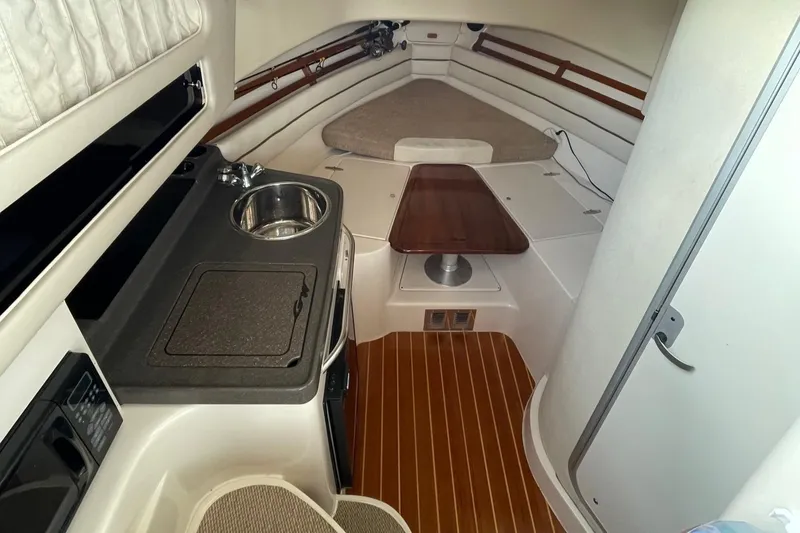 Slide: The Image of Interior of 2005 Grady-White Marlin 300 boat with kitchenette and seating area. - 13