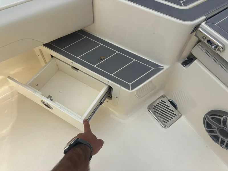Slide: The Image of Open storage compartment on 2025 Scout 281 XSS boat deck. - 16
