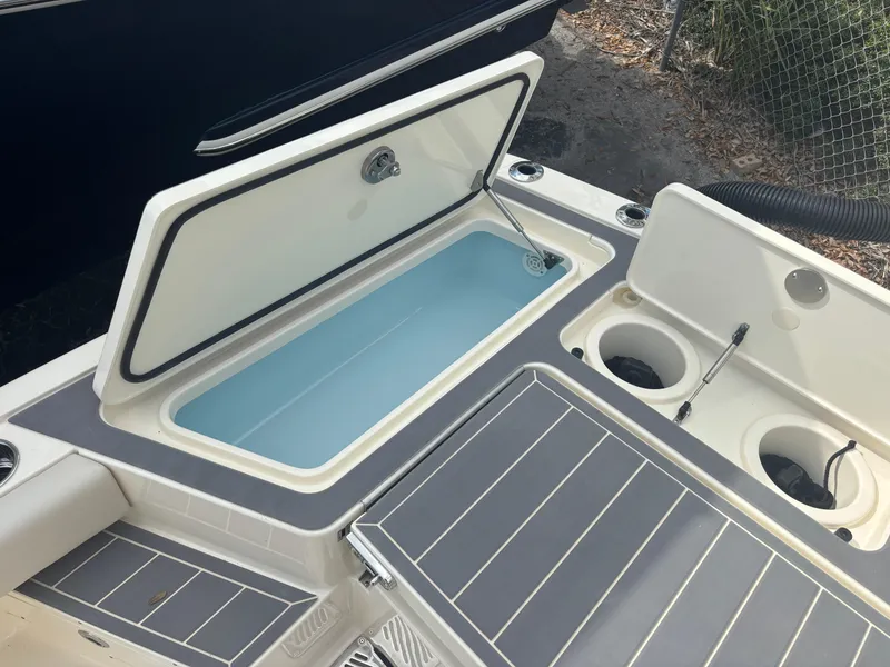 Slide: The Image of 2025 Scout 281 XSS boat with open storage compartments and cup holders. - 17