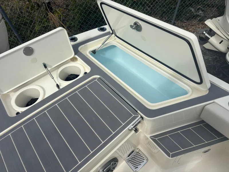Slide: The Image of 2025 Scout 281 XSS boat with open storage compartments and cup holders. - 18