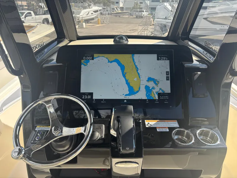 Slide: The Image of 2025 Scout 281 XSS boat dashboard with navigation display and steering wheel. - 5