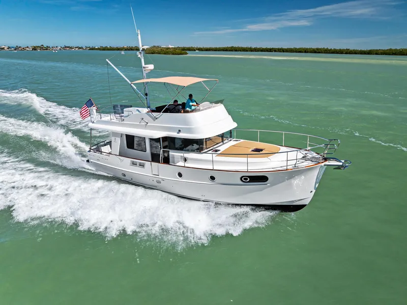 Slide: The Image of 2012 Beneteau Swift Trawler 44 cruising on calm green waters under a clear blue sky. - 1