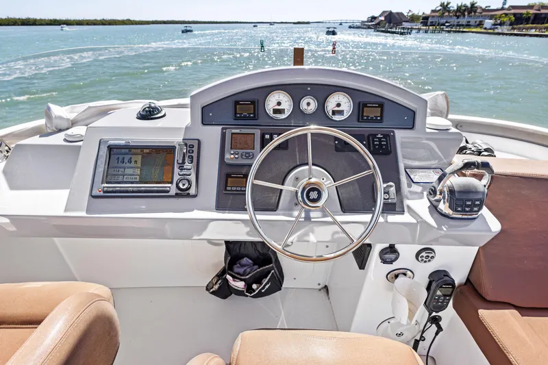 Slide: The Image of Helm of 2012 Beneteau Swift Trawler 44 with navigational instruments, steering wheel, and ocean view. - 10