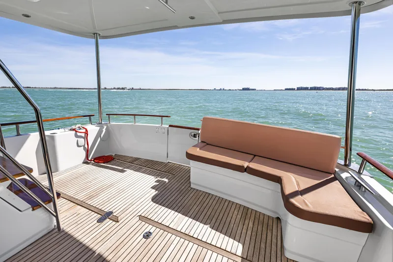 Slide: The Image of 2012 Beneteau Swift Trawler 44 deck with seating, overlooking calm ocean waters. - 13