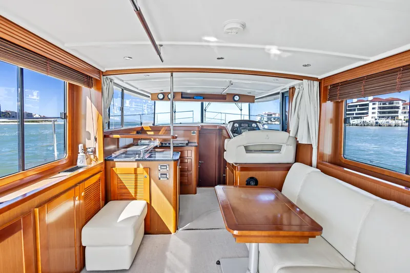 Slide: The Image of Interior of 2012 Beneteau Swift Trawler 44, featuring elegant wood finishes and spacious seating. - 16