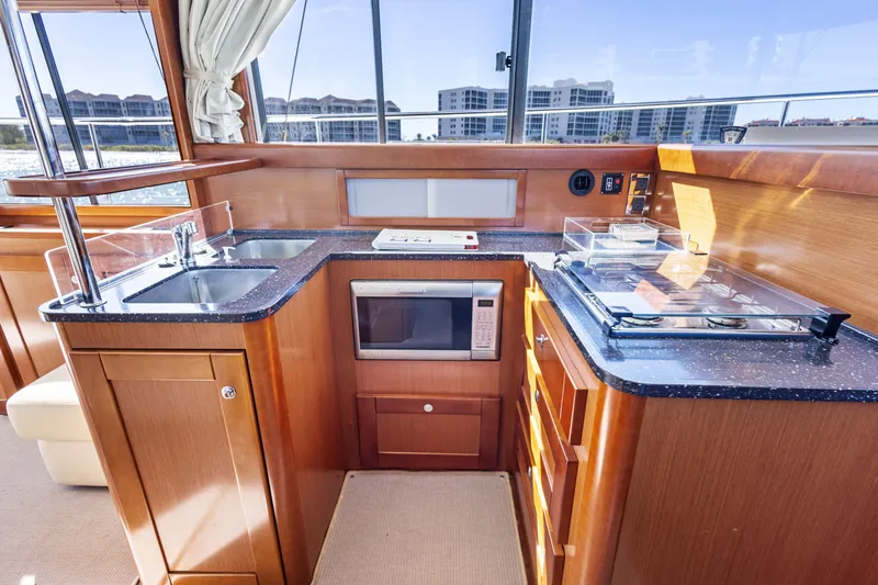 Slide: The Image of Interior of 2012 Beneteau Swift Trawler 44 kitchen with modern appliances and wood cabinetry. - 20