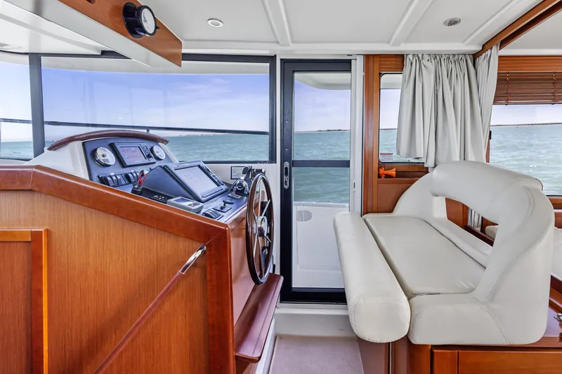 Slide: The Image of Interior of 2012 Beneteau Swift Trawler 44, featuring helm and seating area. - 21