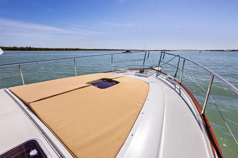 Slide: The Image of 2012 Beneteau Swift Trawler 44 on calm water, showcasing spacious deck and sleek design. - 5