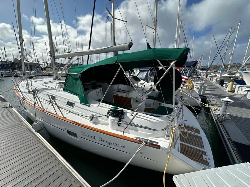 Slide: The Image of 2002 Beneteau 411 sailboat docked at marina, featuring green canopy and sleek design. - 0