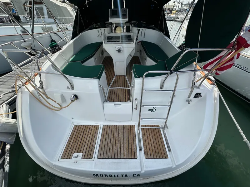 Slide: The Image of Beneteau 411 sailboat, 2002 model, docked with green seating and wooden deck. - 13