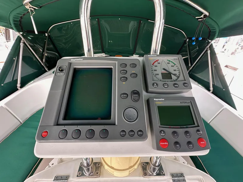 Slide: The Image of Beneteau 411 2002 yacht cockpit with navigation instruments and green canopy. - 17