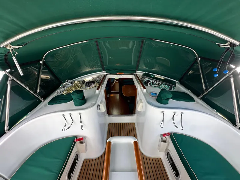 Slide: The Image of Interior view of 2002 Beneteau 411 sailboat cockpit with green upholstery and wood accents. - 23