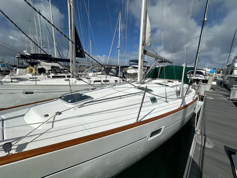 Slide: The Image of 2002 Beneteau 411 sailboat docked at marina under cloudy sky. - 7
